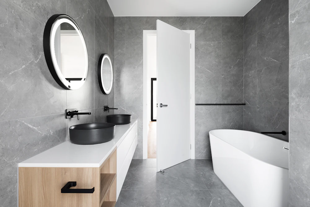 Modern grey tiled bathroom with a freestanding tub