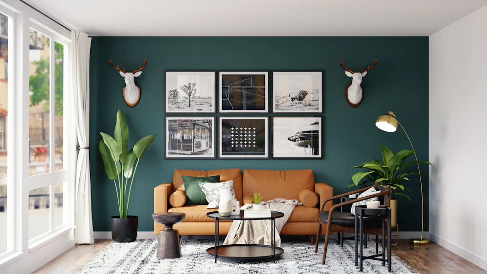 Tan leather sofa against a dark green accent wall